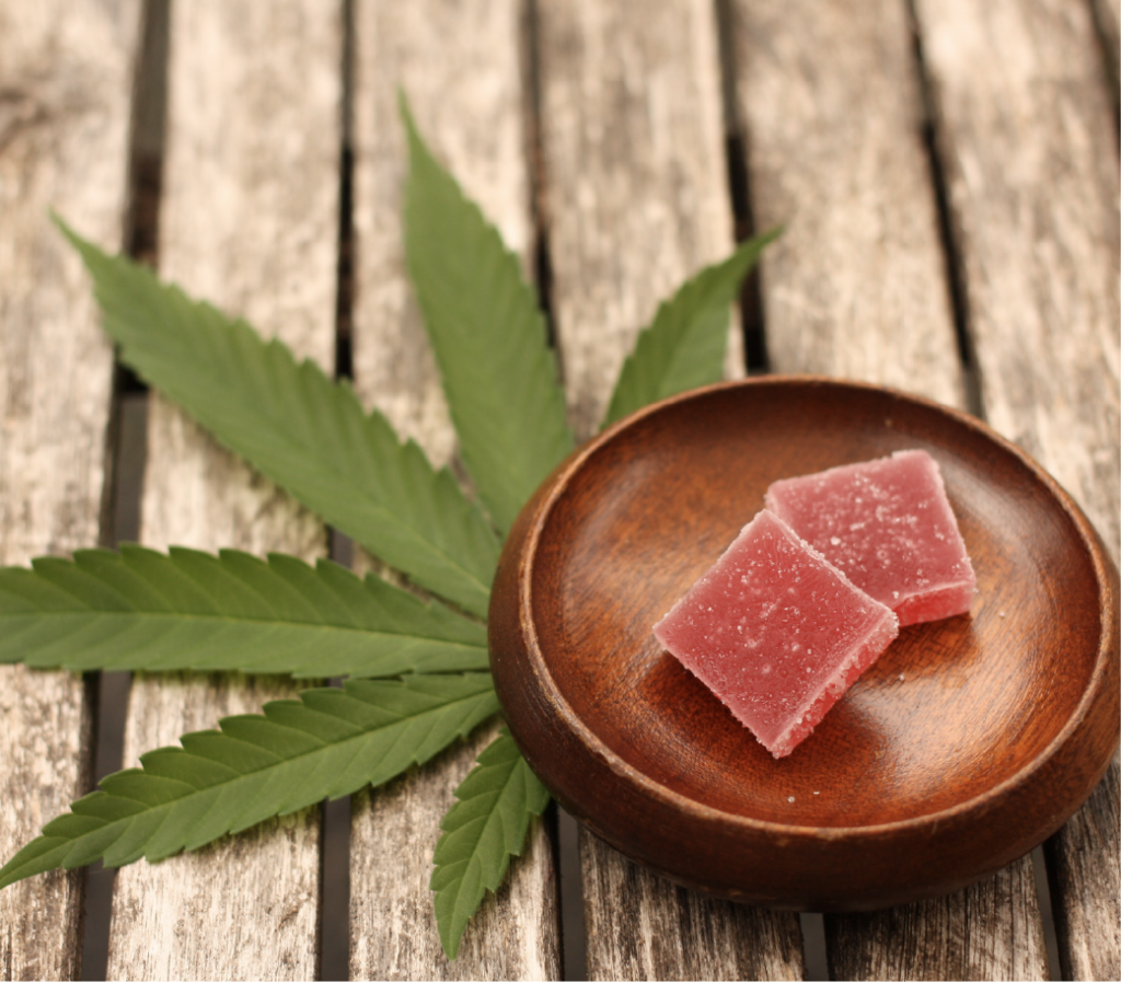 2 edibles on wooden plate with cannabis leaf on table